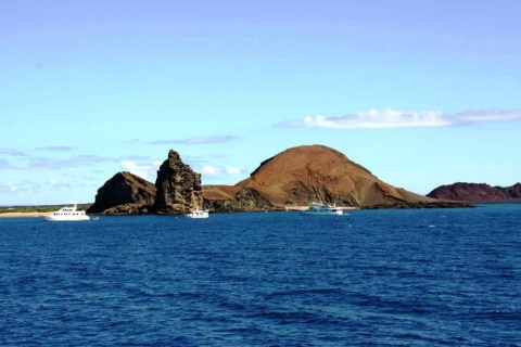 Luxury Galapagos Legend cruise ship sailing near volcanic island